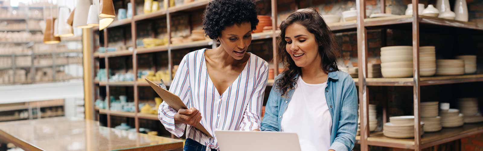 two female business owners discussing their business at pottery store