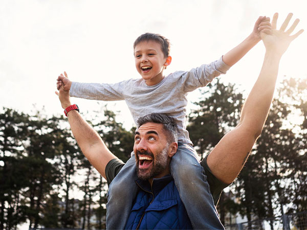 a father with his son on his shoulders outside